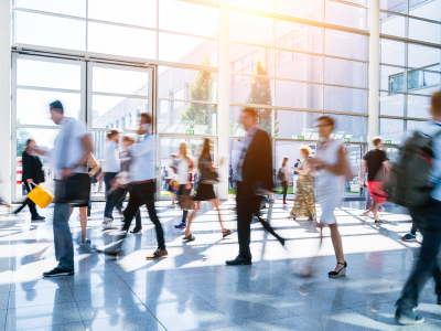 Multiple people blurred and walking through office foyer